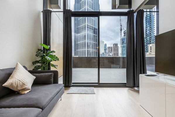The apartment sits against a backdrop of the city that can be seen through the huge, floor-to-ceiling windows that frame the space