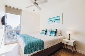 The first bedroom offers a king bed, built-in wardrobes, its own TV and beautiful city views through floor-to-ceiling windows