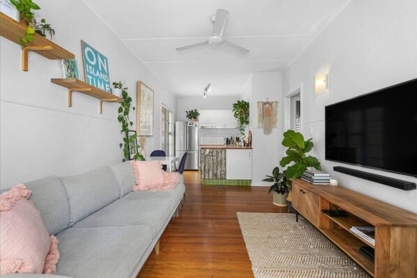 The main living area is open to the kitchen and dining space and equipped with smart TV, ceiling fan, comfortable 3-seater lounge and plenty of greenery.