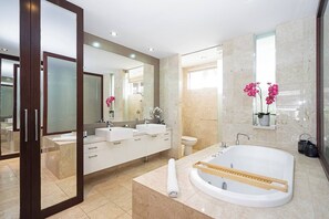 Enjoy a glass of bubbly in this oversized tub. The bathroom also features luxurious double basins and five-star amenities.
