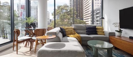 The open plan lounge space is bathed in natural light thanks to full-height windows overlooking the streetscape.
