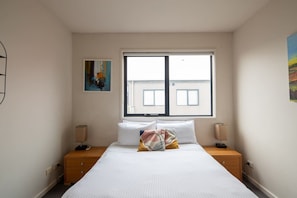 The restful and spacious bedroom, offers a queen bed and plenty of natural light. 