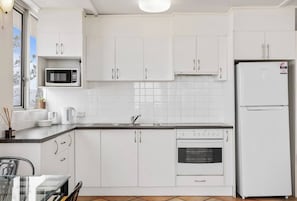 The kitchen is equipped with everything you need to whip up a delicious meal, with a fridge, oven, stove, microwave and coffee maker.