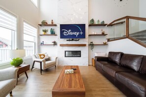 Sunny living room with smart TV, cozy fireplace, and mid-century modern charm.