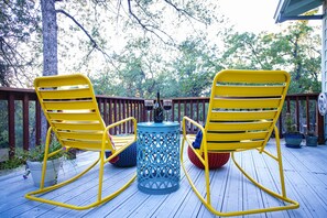 Yellow rocking chairs beckon: share stories, savor drinks, embrace outdoor magic