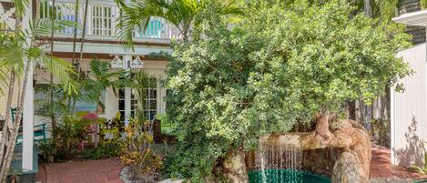 Shared pool area with a waterfall, grotto, and large patio.