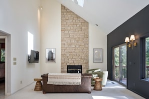 Vaulted ceilings in the Great Room features a fireplace and doors to the expansive rear deck and yard.