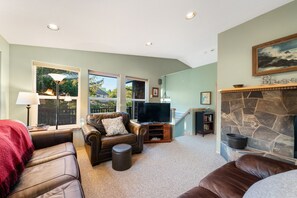 Living room open to dining area. With streaming TV, double sided fireplace (wood not provided)