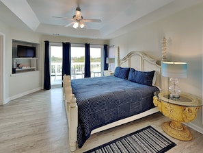 The primary bedroom with a king-sized bed and deck access