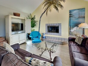 The living area with a fireplace and access to the outdoor patio