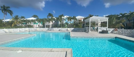 Large, salt-water pool with cabanas, loungers, tables and chairs