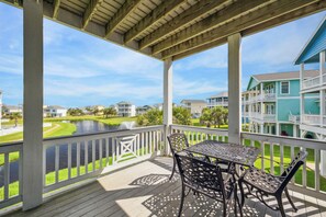 balcony with a view of the neighborhood and the ocean, sit and take in the views.