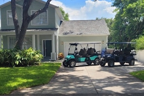 2 six seater golf cars in front of the house