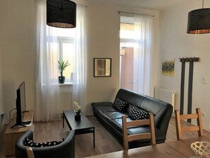 Step into the living room, where Arbio Designers' expertise shines through, creating a warm and inviting atmosphere, perfect for socializing or watching TV.
