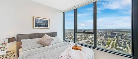 The master bedroom with a queen sized bed & plush pillows.