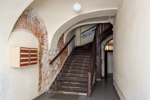 A staircase with exposed brick arches and a rustic design, leading to the upper floors of the building.
