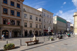 A lively street view showcasing classic architecture, cobblestone roads, and bustling pedestrian activity.
