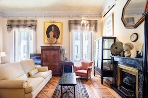 A comfortable sofa, rug, table, armchair and small fridge, kettle, etc.