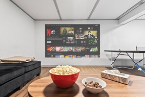 Basement movie & game room with projector, large couch, and ping pong!