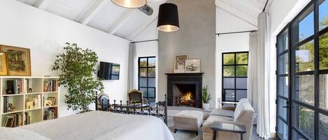 Designed as an artist studio, this 900 sq.ft room has an industrial vibe, scored colored concrete floors, 12"thick masonry walls, 14' vaulted ceiling steel windows and patio doors all welded on site.  The fireplace mantle is 1800's cast-iron. 