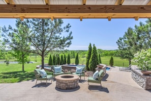 Picturesque 6 acre countryside backyard featuring a sparkling blue swimming pool, a tanning pool, and a fire pit.