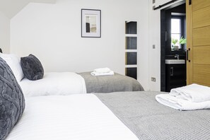 Charming bedroom with two cozy single beds, offering a peaceful retreat for a restful night's sleep or a relaxing getaway.