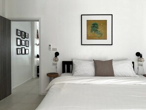 First-floor bedroom with a soft, inviting bed and serene decor. Thoughtfully designed with bedside lighting and charming artwork, this cozy retreat is perfect for a restful night after exploring the city.