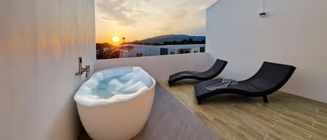 Outdoor bathtub with sun-lounger