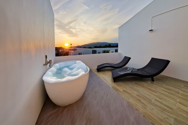 Outdoor bathtub with sun-lounger