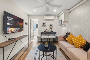 Step into a chic and cozy living space where you can unwind with your favorite Netflix shows on a large screen TV. You will love the stylish decor and inviting atmosphere of this living room.