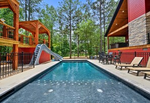 A sleek new pool setup awaits — complete with a slide, loungers, and endless relaxation under the trees.