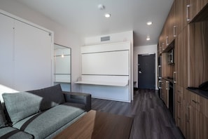 The studio boasts an open concept living space, including living room and kitchenette. The living room can be converted to a bedroom, with a double bed and two single bunk beds.