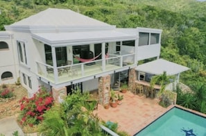 Birds-eye view of outdoor spaces, including pool, cabana bar & covered balcony.