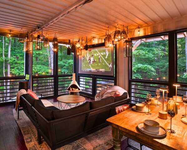 Enjoy forest views while you watch the game! *NOTE* Projector needs phone or laptop. Provided: HDMI, lightning & USBC adaptors! This is a screened in porch, and will be the temperature of the outdoors. We provide 2 gas restaurant style heaters.  