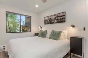 Serene king bed by the window.