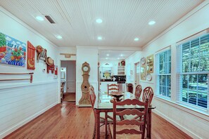 Dining Area with Natural Light – The Stumble Home - Gather around the six-person dining table at The Stumble Home, where hardwood floors, bright windows, and local art set the scene for family meals, game nights, and late-night storytelling.
