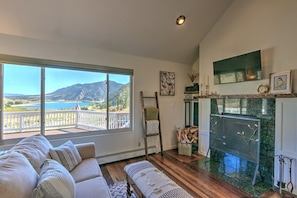 Living room with lake views, wood burning fireplace & TV