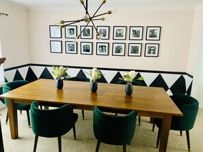 Spacious dining room with 6 chairs and a bench hidden beneath the table.