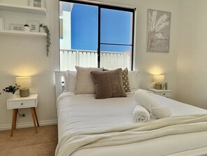Unwind in this bedroom with a comfortable bed, soft linens, and a touch of natural light.