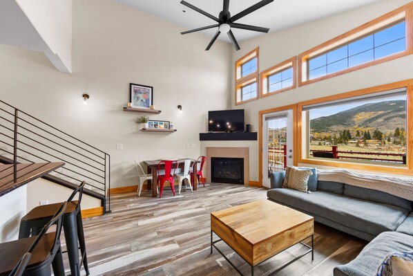 Living room with mountain views, private balcony, gas fireplace, and vaulted ceilings.