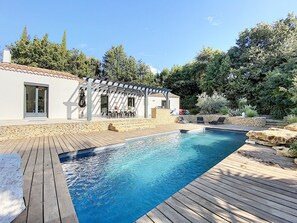 Vue extérieur de la piscine, terrasse avec table et barbecue