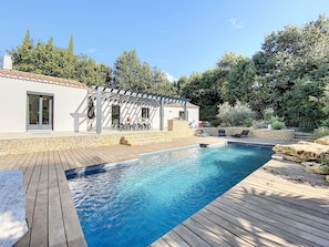 Vue extérieur de la piscine, terrasse avec table et barbecue