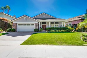 View of garage, front lawn, and front entrance