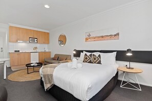 Unwind in this spacious studio, featuring a comfortable bed and a warm seating area.