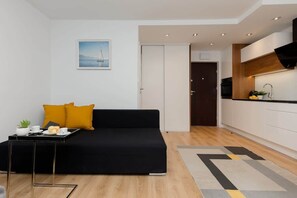 A wide view of the open-plan space, showcasing the living, dining, and kitchen areas with a cohesive layout.
