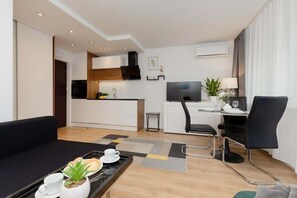 A modern interior with a black sofa, dining table, and wood accents, creating a cozy and functional atmosphere.
