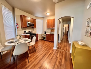 Fully stocked kitchen with appliances, essential cookware, and dinnerware.