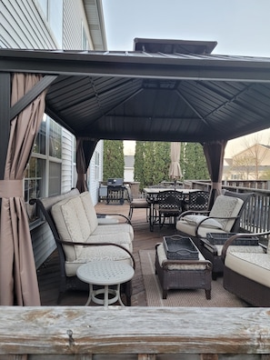 Year round use gazebo with closing curtains and patio furniture.