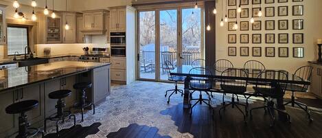 Dining room, gothic window w/ bifold door, gourmet island, and industrial table