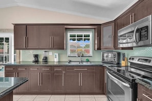 Prepare your meals with ease in the kitchen, boasting exquisite countertops, and furnished with a fridge, stove, microwave, and all the necessary utensils.